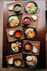 Assorted traditional meals served on wooden trays in cozy rustic setting, top view