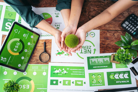 Business leaders hands collaborate analyzing environmental sustainability data for corporate responsibility action plan development