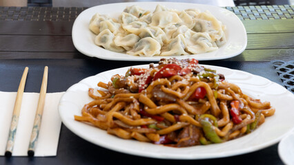 Traditional Uighur Laghman Noodles with Vegetables and Meat on a Rustic Table