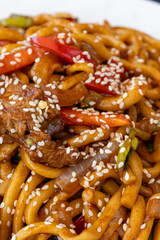 Traditional Uighur Laghman Noodles with Vegetables and Meat on a Rustic Table