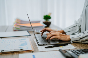 Female office worker working with financial reports for tax audit reports or financial statement in a meeting room. Cropped shot