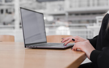 Young white woman working on computer with blank copy space screen on table in home office. close...