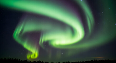 A mesmerizing swirling vortex of the green aurora borealis dances across a clear starry night sky creating a breathtaking celestial display.