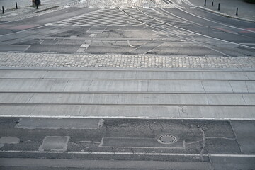 Empty Intersection with Curved Tram Tracks on Asphalt and Concrete
