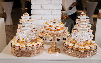 Luxury candy bar with cupcakes, macarons, and desserts on elegant golden trays
