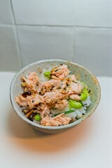Salmon teriyaki poke bowl featuring glazed fish, sesame sprinkles, steamed rice, edamame garnish