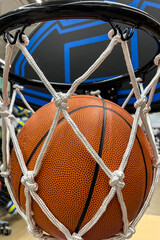 A closeup of a basketball falling through the net to score points
