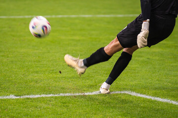 Goalkeeper kicks the ball during the soccer match.