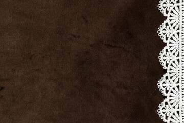Brown velour background with white lace pattern side edge as decorative background, texture