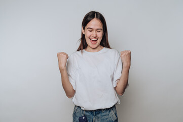 Young woman celebrating with clenched fists and closed eyes
