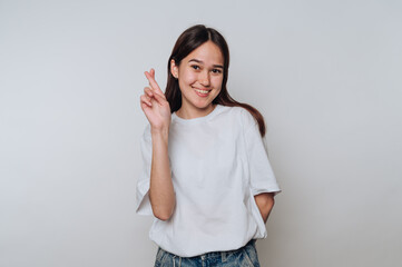 Smiling woman with long hair crossing fingers on one hand.
