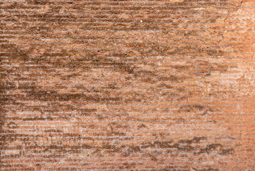 Ancient wall made of layered stones and bricks, combining earthy textures and aged architectural details