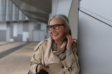 Joyful woman with glasses enjoying her day in modern urban setting during daylight hours