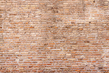 Detailed texture of an aged brick wall with earthy tones and worn-out surface