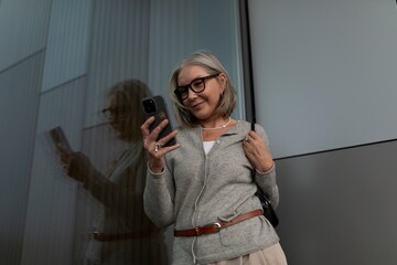 Woman enjoying a moment with her smartphone in an urban setting during daylight hours
