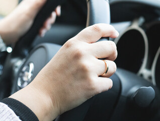 Woman's Hand on Car Steering Wheel Showing Wedding Ring – Lifestyle and Driving Concept