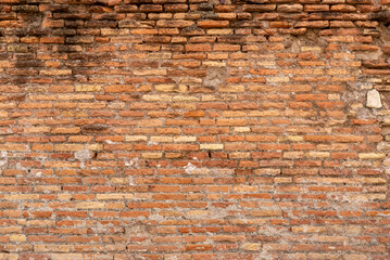 Close-up of ancient brick wall with rough surface and earthy colors, highlighting historic...