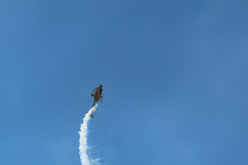 Helicopter climbing vertically with spiral smoke trail.