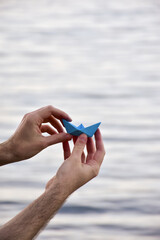 Conceptual image of a paper boat on neutral background with text space, symbol of journey and personal growth