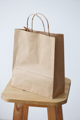 Plain brown paper bag on wooden stool