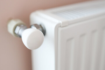Close-up of white radiator with temperature control valve in modern interior