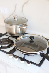Modern stainless steel cookware on gas stove in minimalist kitchen setting