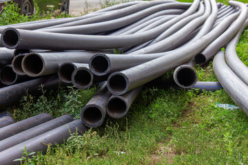 Coiled Black Pipes on Green Grass