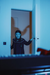 Playful Girl in a Mysterious Blue-lit Doorway