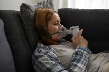 Nebuliser aerosol. Middle age woman with inhaler machine, seasonal flu