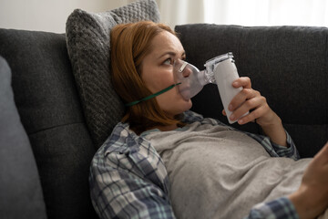 Nebuliser aerosol. Middle age woman with inhaler machine, seasonal flu
