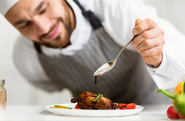 Professinal Chef Cook Man Pouring Sauce On Chicken Plating Dish Standing In Kitchen Indoor. Selective Focus