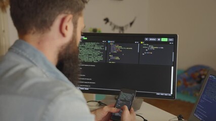 Software developer working from home using smartphone and computer - Powered by Adobe