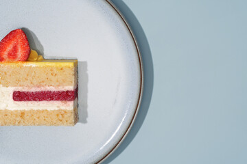 Lemon and strawberry cake slice on a white plate, showcasing vibrant colors and textures, perfect...