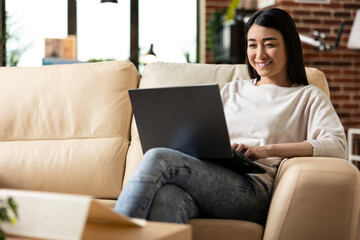 Female freelancer researching strategies and reviewing emails while managing tasks remotely. Asian...