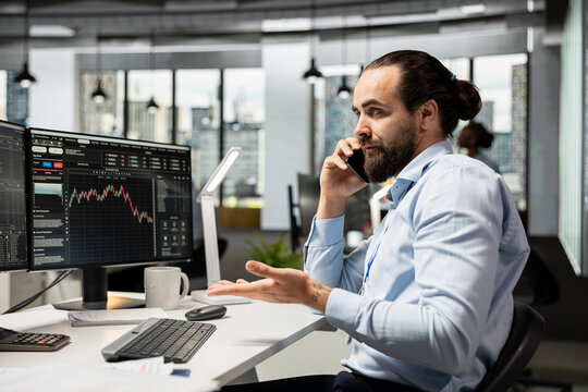 Brokerage firm trader answering telephone call from angry client upset after stock market shares price drop. Investment consultant talking on phone with frustrated customer losing money