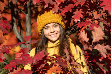 Child teen girl in autumn fall park outdoor, autumn fun kids face. glad teen kid in hat at autumn...