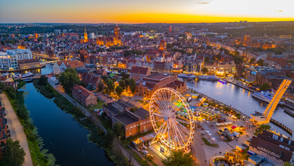 Fototapeta premium Sunset panorama of Gdansk behind a ferris wheel, Poland