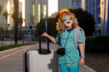 Traveler tourist kid boy 7-8 years old. Passenger traveling abroad to travel on weekends getaway. Independent kid boy with big travel bag.