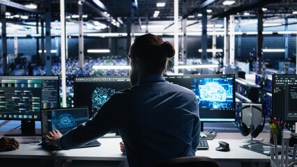 Server room software developer using AI to review infrastructure diagnostics. IT employee in data...