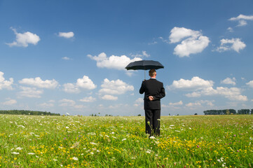 The person in a dark business suit with an umbrella