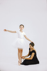 Mother and daughter ballet dancers against white background