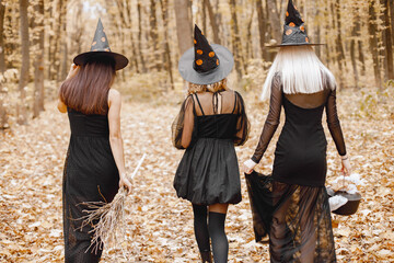 Three witches walking in forest on Halloween
