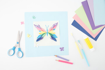 Colorful handmade greeting card with 3D paper butterfly, Flat lay DIY craft project with tools. Suitable for paper art tutorials, craft bloggers, and creative workshops,