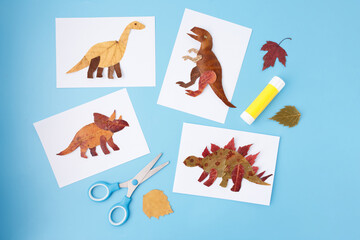 Scissors glue stick and dried autumn leaves on blue desk flat lay composition copy space educational craft workshop diy activity design for banner seasonal advertising school marketing,