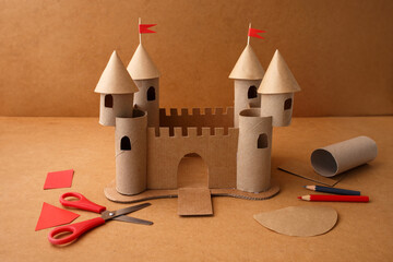 Recycled cardboard castle DIY craft project with paper tools on table, perfect for kids art...