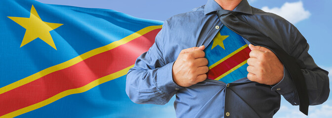 A businessman opening his shirt like super hero with Democratic Republic of Congo flag and shows how patriotic he is by revealing his countries flag beneath printed on a t-shirt.
