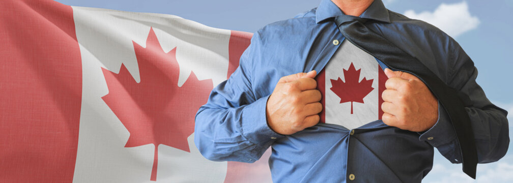 A businessman opening his shirt like super hero with Canada flag and shows how patriotic he is by revealing his countries flag beneath printed on a t-shirt.