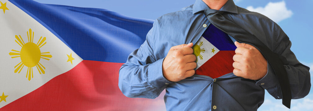 A businessman opening his shirt like super hero with Philippines flag and shows how patriotic he is by revealing his countries flag beneath printed on a t-shirt.