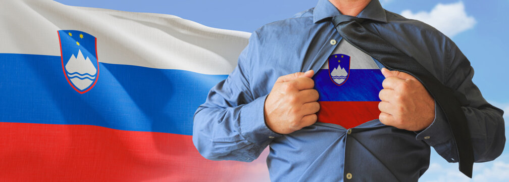 A businessman opening his shirt like super hero with Slovenia flag and shows how patriotic he is by revealing his countries flag beneath printed on a t-shirt.