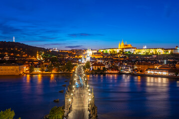 Fototapeta premium Sunset view of people passing Charles bridge towards Prague cast